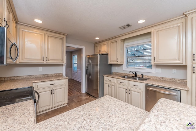 kitchen featuring sink, stainless steel appliances, and cream cabinets