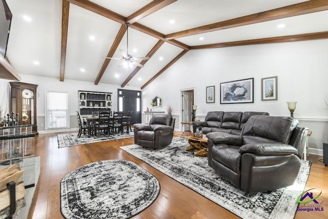 living room with light hardwood / wood-style floors, lofted ceiling with beams, and ceiling fan