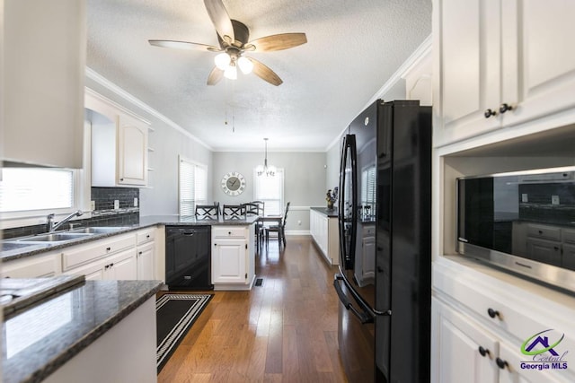 kitchen with tasteful backsplash, black appliances, sink, hanging light fixtures, and white cabinets