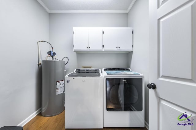 clothes washing area with hardwood / wood-style flooring, washer and clothes dryer, water heater, ornamental molding, and cabinets