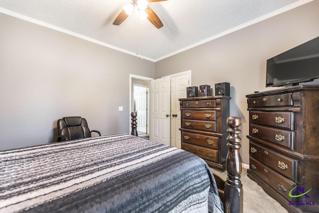 carpeted bedroom with a textured ceiling, ceiling fan, and ornamental molding