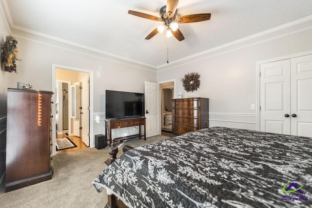 carpeted bedroom with ceiling fan, a closet, and crown molding