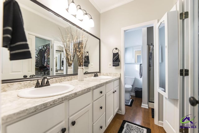 bathroom with toilet, vanity, wood-type flooring, and ornamental molding