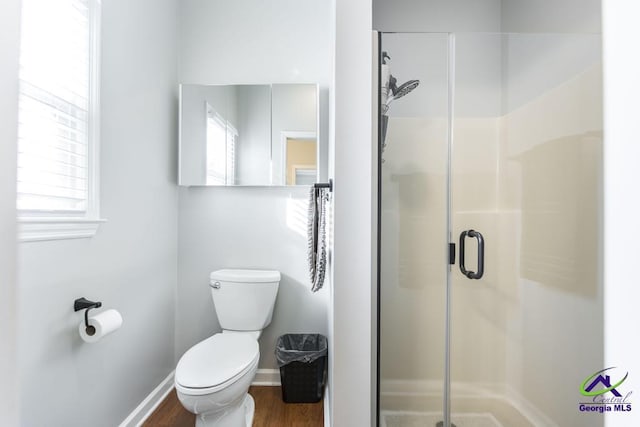 bathroom featuring wood-type flooring, toilet, and walk in shower