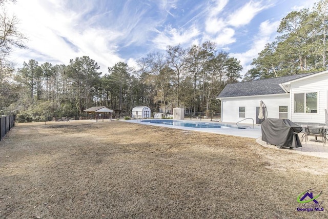 view of yard featuring a storage unit, a patio area, and a fenced in pool