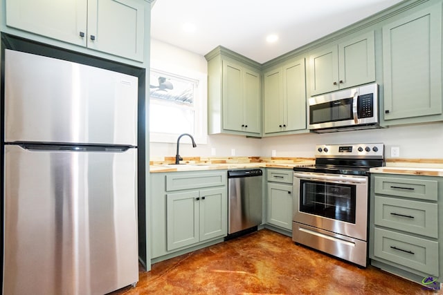 kitchen with green cabinetry, appliances with stainless steel finishes, and sink