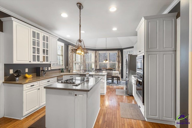 kitchen with white cabinets, pendant lighting, stainless steel appliances, and a center island