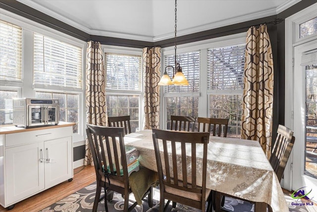 dining room featuring an inviting chandelier, crown molding, and light hardwood / wood-style flooring