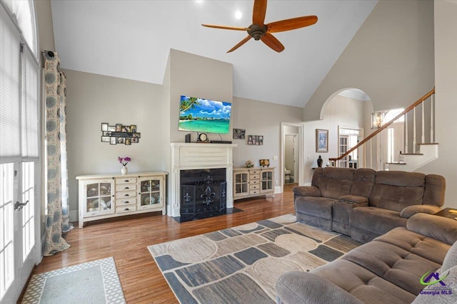 living room featuring high vaulted ceiling, ceiling fan, and wood-type flooring