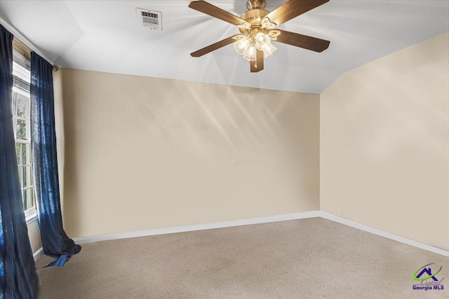 empty room with ceiling fan, carpet floors, and vaulted ceiling