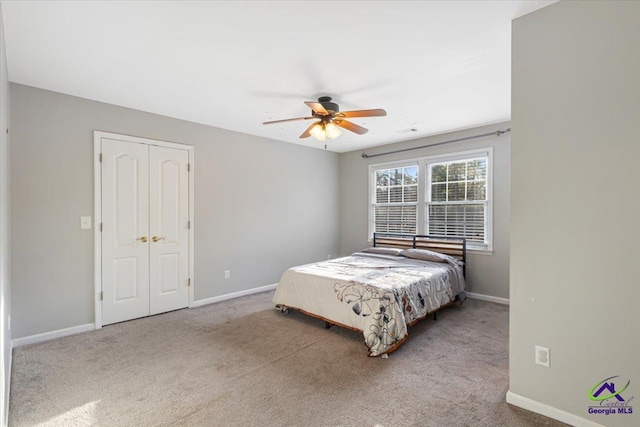 bedroom featuring light carpet, ceiling fan, and a closet