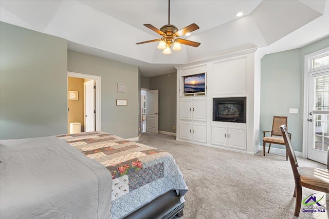 bedroom featuring ceiling fan, light carpet, and a raised ceiling