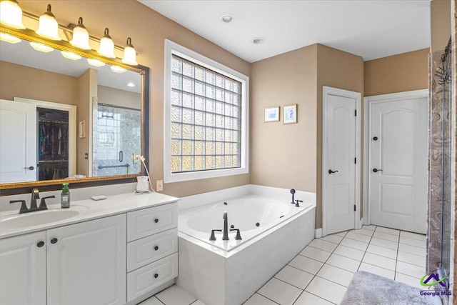 bathroom featuring tiled bath, tile patterned flooring, and vanity