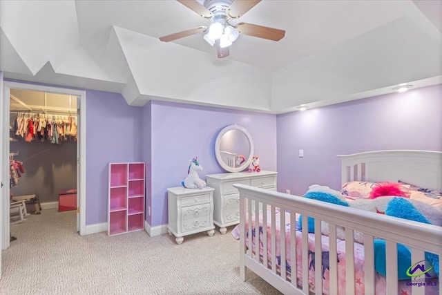 bedroom featuring light carpet, a closet, a spacious closet, and ceiling fan