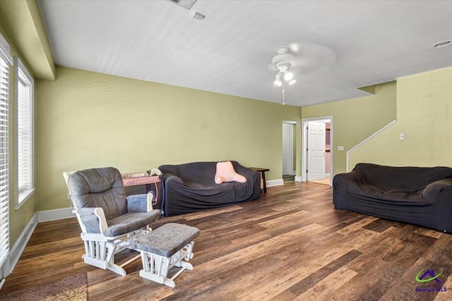 living room with ceiling fan and dark hardwood / wood-style flooring