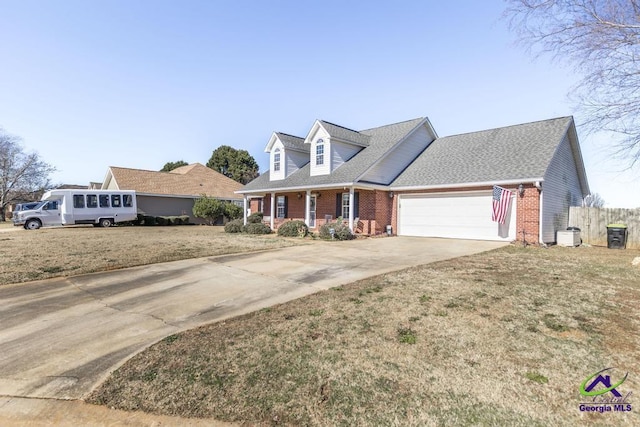 cape cod-style house featuring a garage, a front yard, and a porch