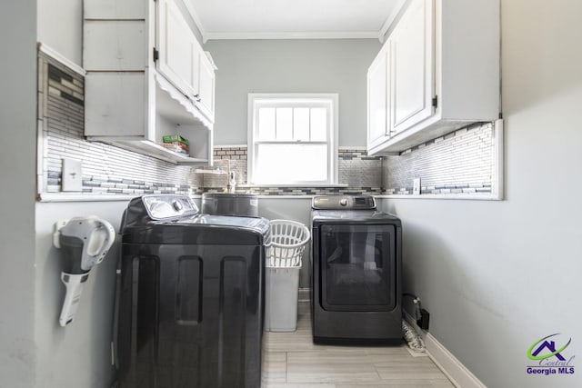 laundry room with cabinets, sink, crown molding, and washing machine and dryer