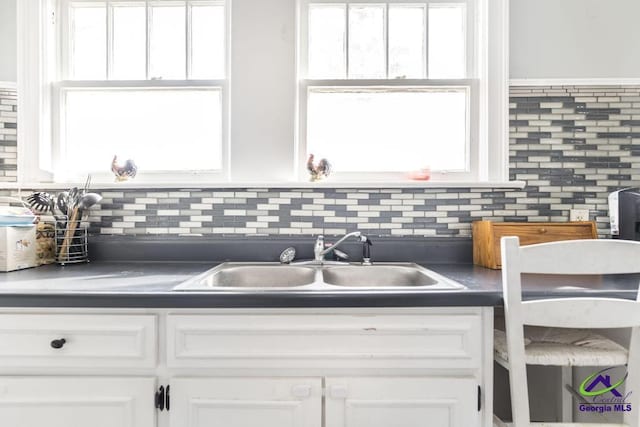 kitchen featuring sink, white cabinets, and tasteful backsplash