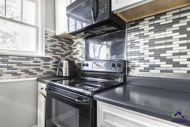 kitchen featuring white cabinets, black appliances, and tasteful backsplash