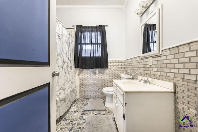 bathroom with toilet, vanity, tile walls, and ornamental molding