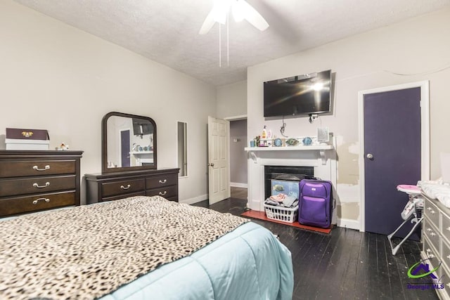 bedroom featuring dark wood-type flooring, ceiling fan, and a textured ceiling