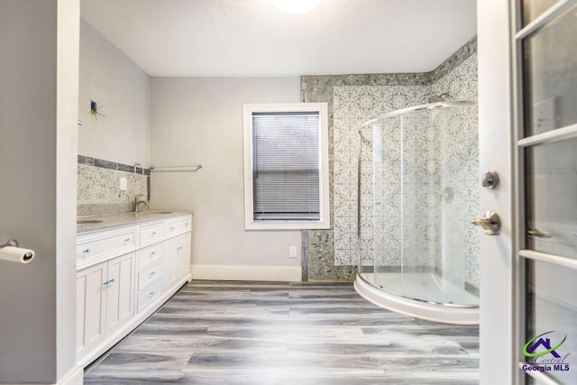 bathroom with an enclosed shower, vanity, and hardwood / wood-style floors