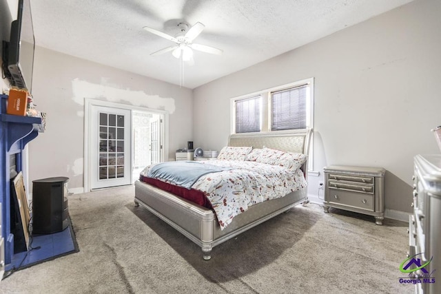 carpeted bedroom featuring ceiling fan and a textured ceiling