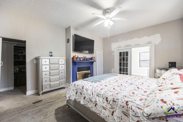 bedroom with a textured ceiling, ceiling fan, and carpet floors