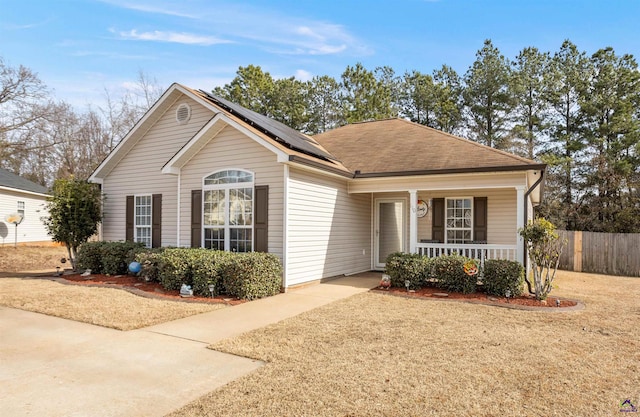 view of front of home featuring covered porch and solar panels