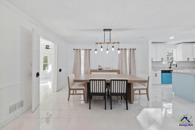 tiled dining room with sink and ornamental molding