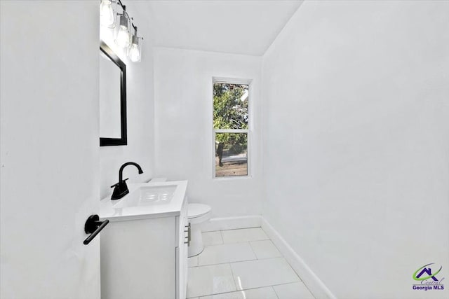 bathroom with toilet, vanity, and tile patterned floors