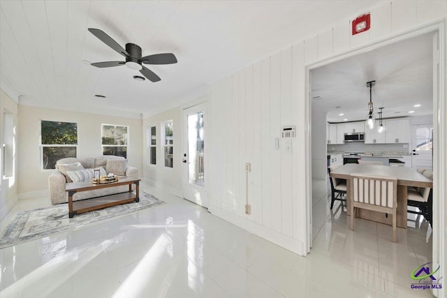 living room featuring ceiling fan and ornamental molding