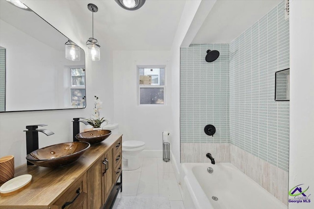 full bathroom featuring toilet, tiled shower / bath combo, and vanity