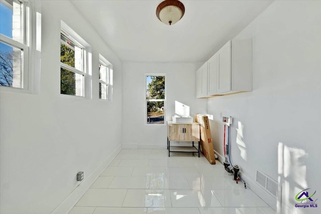 laundry room with a wealth of natural light and light tile patterned flooring