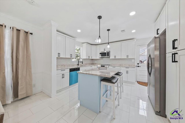 kitchen featuring a kitchen island, white cabinetry, hanging light fixtures, light stone countertops, and appliances with stainless steel finishes