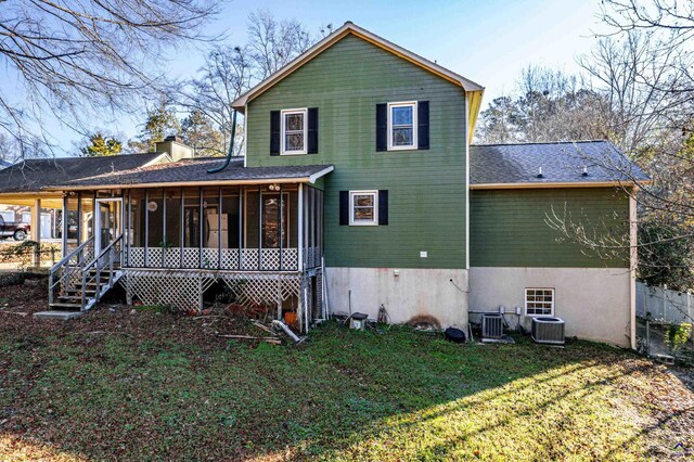 rear view of property featuring a sunroom, cooling unit, and a yard