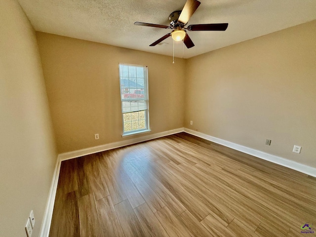 spare room with light hardwood / wood-style floors, a textured ceiling, and ceiling fan