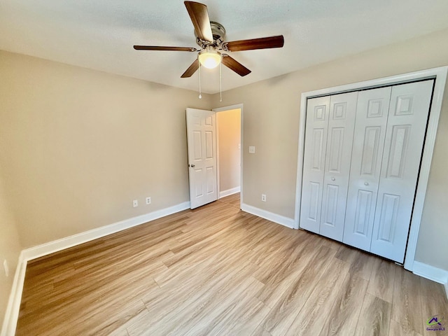 unfurnished bedroom featuring ceiling fan, a closet, and light hardwood / wood-style flooring