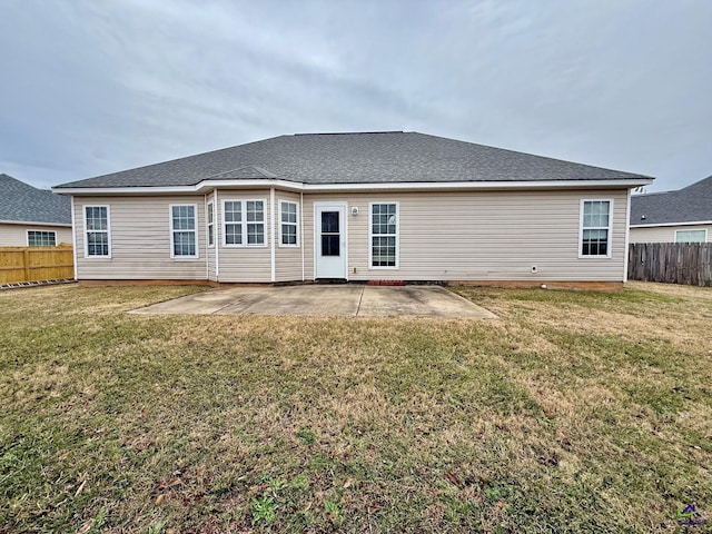 rear view of house featuring a lawn and a patio