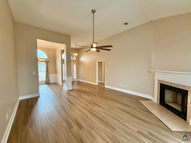 unfurnished living room featuring ceiling fan, vaulted ceiling, light wood-type flooring, and a fireplace