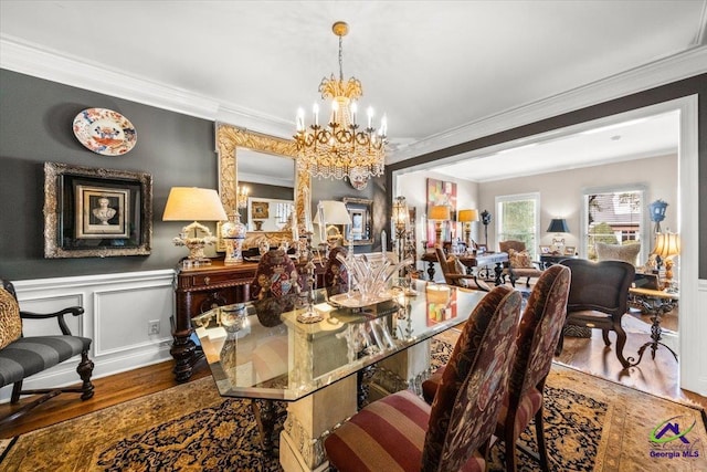 dining room featuring an inviting chandelier, ornamental molding, and wood-type flooring