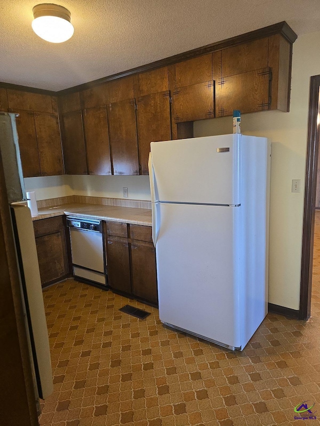 kitchen featuring white appliances and a textured ceiling