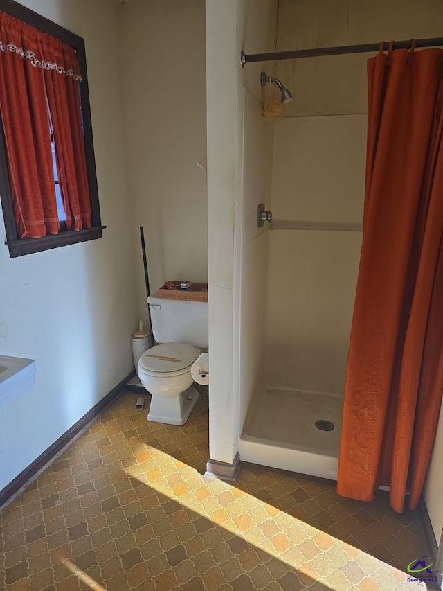 bathroom with toilet, tile patterned floors, and a shower with curtain