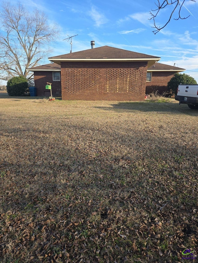 rear view of property featuring a lawn