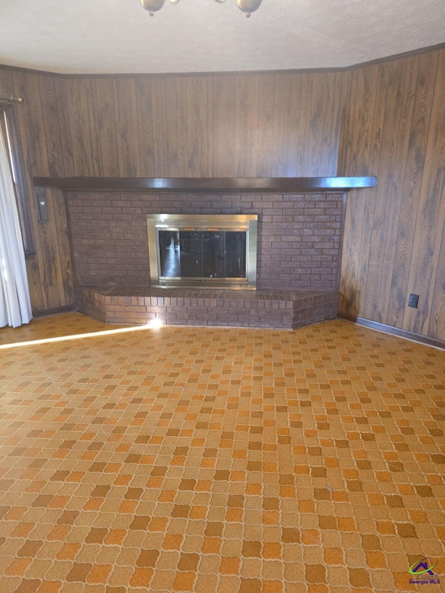 unfurnished living room with wood walls and a fireplace