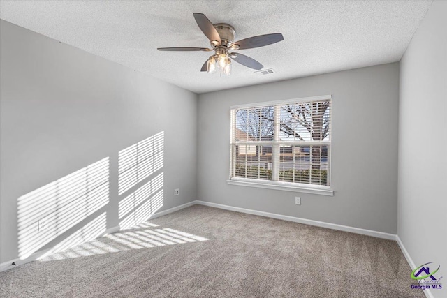 carpeted spare room featuring a textured ceiling and ceiling fan