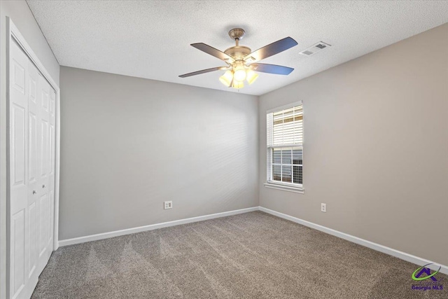 unfurnished bedroom with a closet, carpet, and ceiling fan