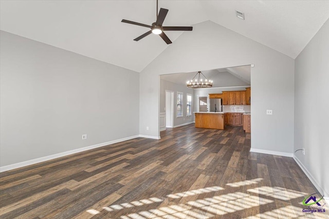 unfurnished living room with high vaulted ceiling, dark hardwood / wood-style floors, and ceiling fan with notable chandelier