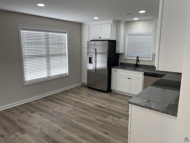 kitchen featuring wood-type flooring, appliances with stainless steel finishes, sink, and white cabinetry