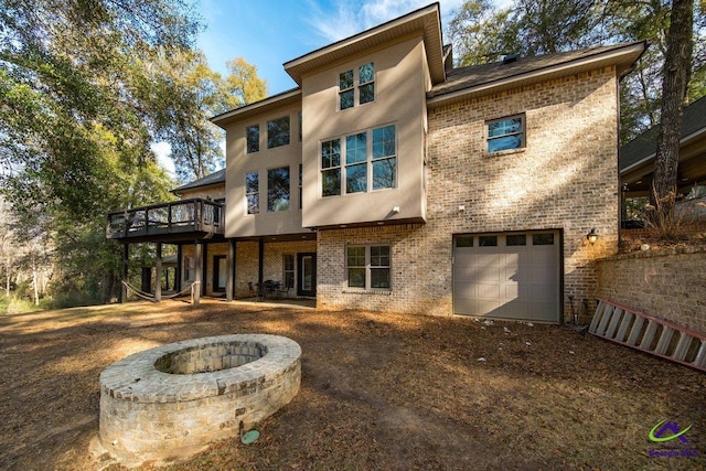 back of property featuring a garage and a fire pit